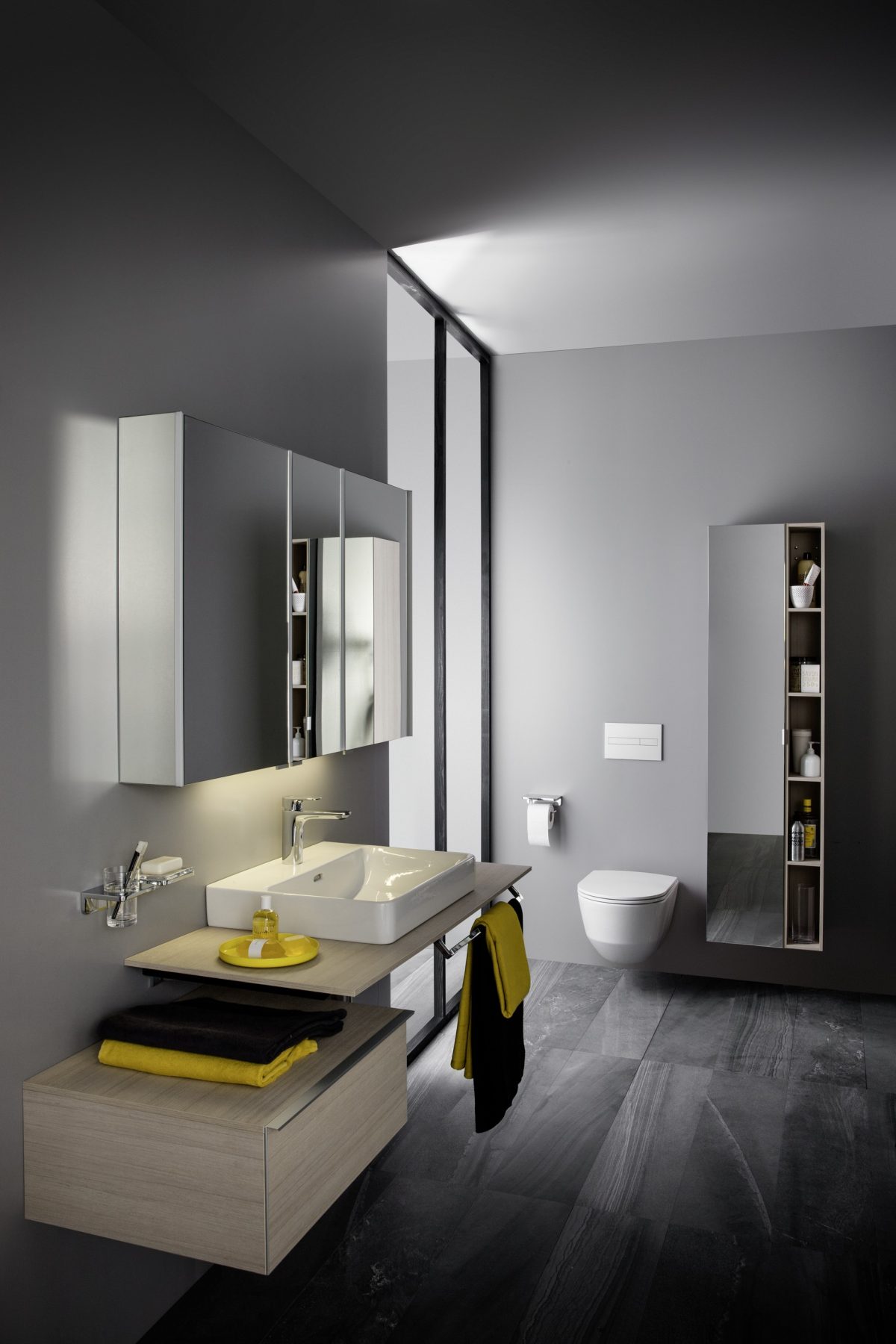 Luxury bathroom style with dark grey walls and flooring with yellow and black items.