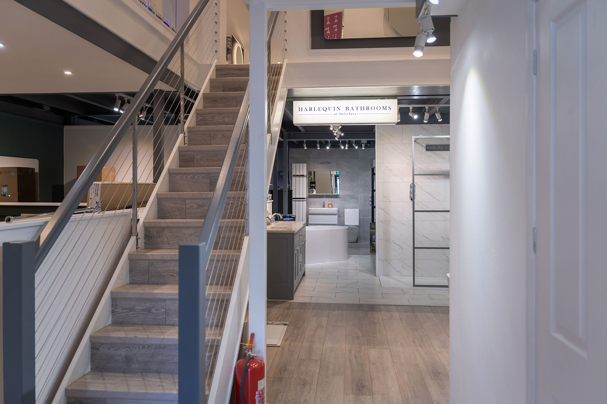 Harlequin bathrooms showroom looking into rear room and stairs going up.